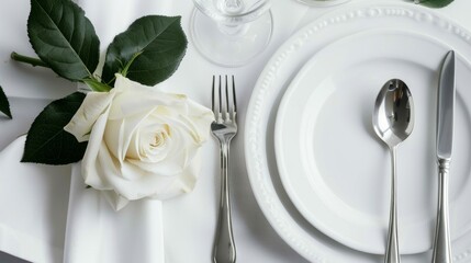 Elegant table setting with white rose and silverware