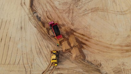 Drone view of bulldozers and dump trucks burying nuclear waste at remote site. Heavy machinery...