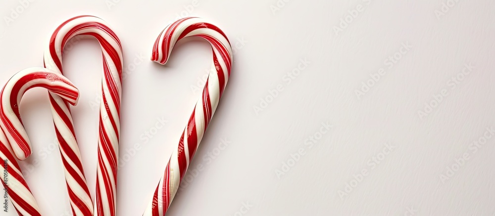 Poster Close-up of candy canes with stripes for New Year's on a white background with space for writing. image with copy space