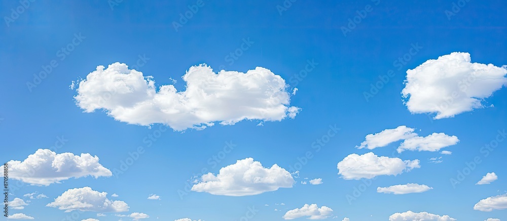 Poster Daytime scene showing white clouds set against a clear blue sky background with ample copy space image available.