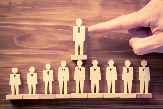 A finger is pointing at the  boss of organization in wooden doll theme