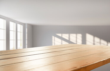 An elegant and subtle abstract light backdrop for product display with graceful and subtle shadows cast by tree branches on the wall. rays of the window, with an empty table