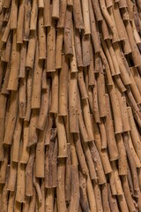 Close-up of a textured surface made of natural wooden sticks arranged vertically