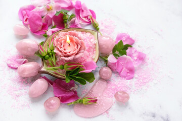 set of Rose quartz crystals, flower candle, sea salt and wild rose flowers and petals on marble background. Healing Crystals For Body Care, Relationship, Self care. meditation ritual. close up