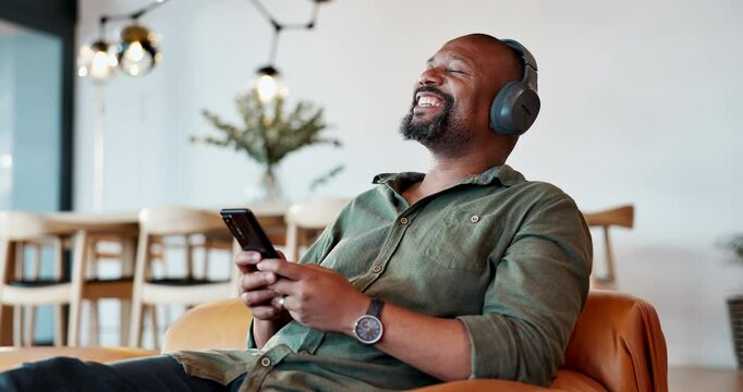 Black man, relax and headphones with music on phone for streaming video, podcast and networking on social media. African, male person and mobile for listening, playlist audio and dancing at home
