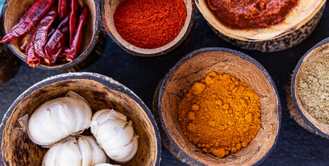 Natural Indian food ingredients. Exotic Mediterranean food on black cutting board background. Top view fresh food, groceries in wooden bowls