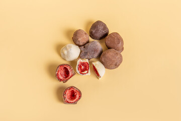 Dried strawberries in chocolate on beige background. Strawberries in dark, milk and white chocolate. Healthy vegan sweets