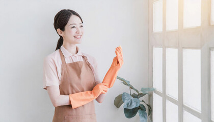 室内でエプロンをつけた女性。家事代行サービスで働く女性。