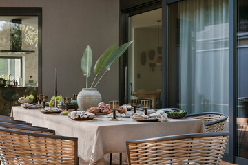 Interior design of  terrace with table, garden chair, vase with flowers, bowl with fruits, tableware, beautiful garden and personal accessories. Home decor. Template.