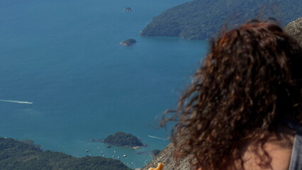 Slow-motion view of long-haired woman admiring paradise island