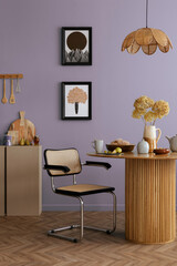 Warm and cozy dining room and kitchen interior with mock up poster frame, round table, rattan chair, beige commode, blue wall, vase with flowers and kitchen accessories. Home decor. Template.