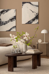 Spring living room interior with mock up poster frame, wooden coffee table, boucle sofa, round carpet, stylish lamp, sculpture, vase with magnolia and personal accessories. Home decor. Template.
