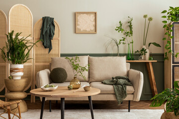 Interior design of spring living room interior with mock up poster frame, beige sofa, wooden coffee table, plants in flowerpots, rattan sideboard and personal accessories. Home decor. Template.