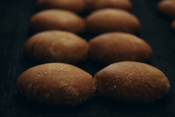 Fresh baked bread and wheat ears on a wooden background