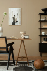 Cozy composition of workplace interior space with mock up poster frame, wooden desk, rattan chair, black lamp, books, patterned carpet, marble bowl and personal accessories. Home decor. Template.