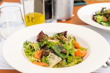 Healthy morning meal with salmon, olive oil, avocado, fresh herbs, cheese and tomatoes