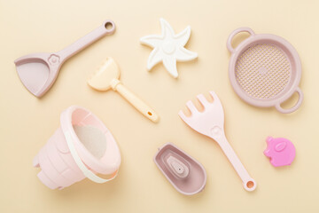 Cute toys for playing with sand on color background, top view
