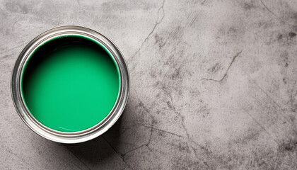 Green paint in metal can on cement surface. For wall painting or artwork. Close-up. Top view.