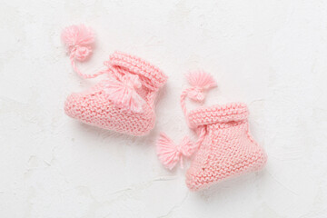 Pink baby booties on white background, top view