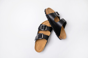 Black leather sandals with cork soles on a white background, top view flat lay. Trendy fashionable...