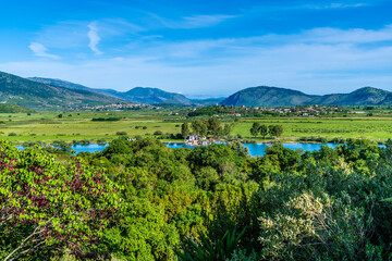 A view towards settlements across the Corfu Strait from the castle in the ancient ruins at Butrint, Albania in summertime