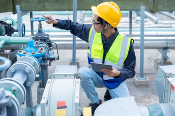 Engineer checks water tank valves, equipment related to hot water production pipelines.