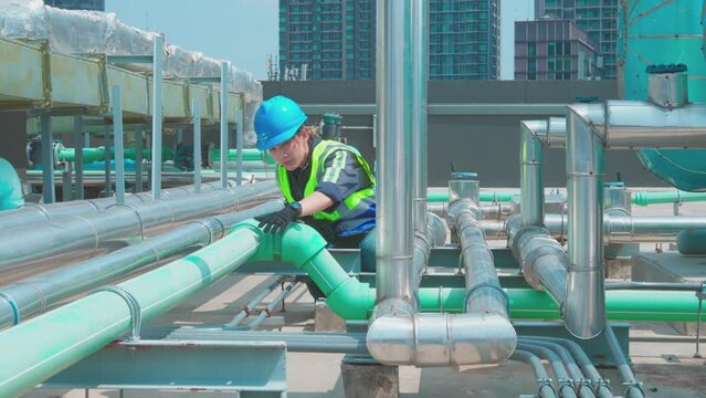 Engineer under checking the industry chilled water fan coil unit air conditioner is water cooling tower air chiller HVAC system of large industrial building to control air system
