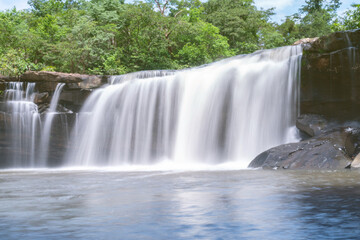 Obraz premium The source of the river in the forest. waterfall with forest in the background.Lake waterfall , Mountains trees Nature.The beautiful peguche waterfall flowing.