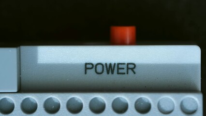 Man fingertip presses against power button activating device. Worker in process of turning on device or appliance with deliberate action