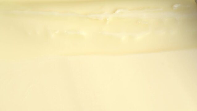 Cutting the fresh butter with knife, macro shot. Putting knife into butter, close up.