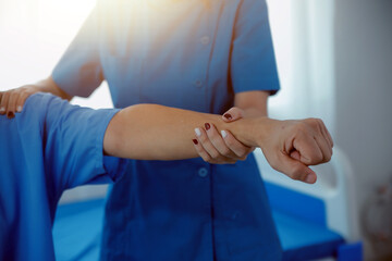 Physiotherapist man giving exercise with dumbbell treatment About Arm and Shoulder of athlete male patient Physical therapy concept