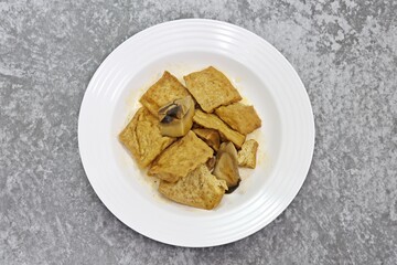 Stir Fried Tofu and Shiitake Mushroom with Szechuan Sauce on white plate