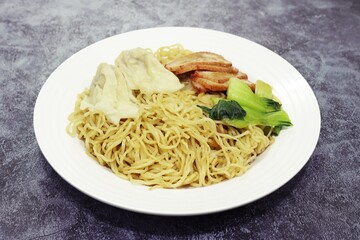 Egg Noodle with Pork Wonton and BBQ Pork in white plate, close up photo high angle view