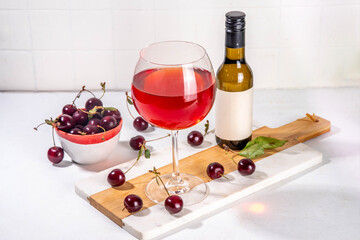 Sweet alcohol cherry wine drink, homemade cherry wine or liquor with ripe fresh red cherries on...
