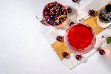 Sweet alcohol cherry wine drink, homemade cherry wine or liquor with ripe fresh red cherries on...