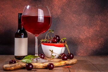 Sweet alcohol cherry wine drink, homemade cherry wine or liquor with ripe fresh red cherries on...
