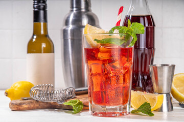 Cola and wine sweet sour alcoholic drink, Kalimotxo or calimocho boozy fizzy cocktail with ice cubes, lemon and mint, copy space