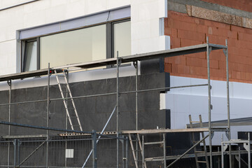 insulating the walls with modern thermal insulation materials. The new house construction process involves Exterior covering is applied at the construction site.
