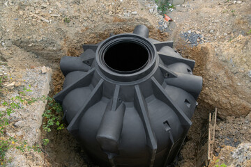 New septic tank for collecting rainwater or separate sewage. container underground on the...
