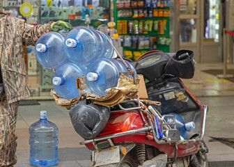 Large Water Bottles Delivery at Scooter Motorcycle in City