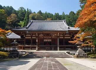 A Buddhist temple with a long walkway leading up to it, surrounded by trees with red autumn leaves