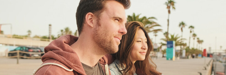 Close-up of young happy couple sitting in seaport, panorama