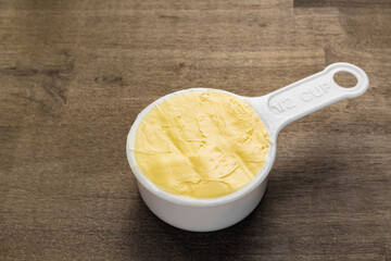 Half cup of butter on rustic wood