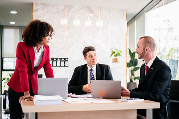 Three men and a woman are sitting at a conference table