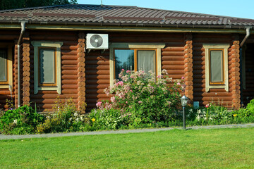 Log cabin with air conditioner and flowers