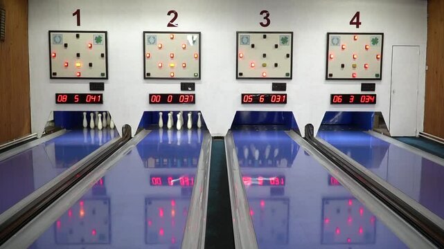 Bowling game in the sports center. The bowling ball knocks down the skittles.   Game in bowling club. Skittles and bowling ball.  
