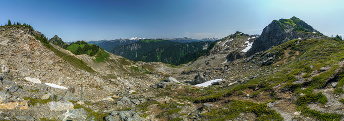 A mountain range with snow on the peaks and a clear blue sky