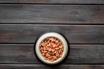 Bowl of biscuits for pets - food in a shape of heart, top view