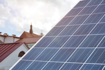 Obraz premium Element of a solar power plant against the backdrop of a classic historical city.