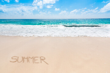 Summer written on a tropical beach with golden sand